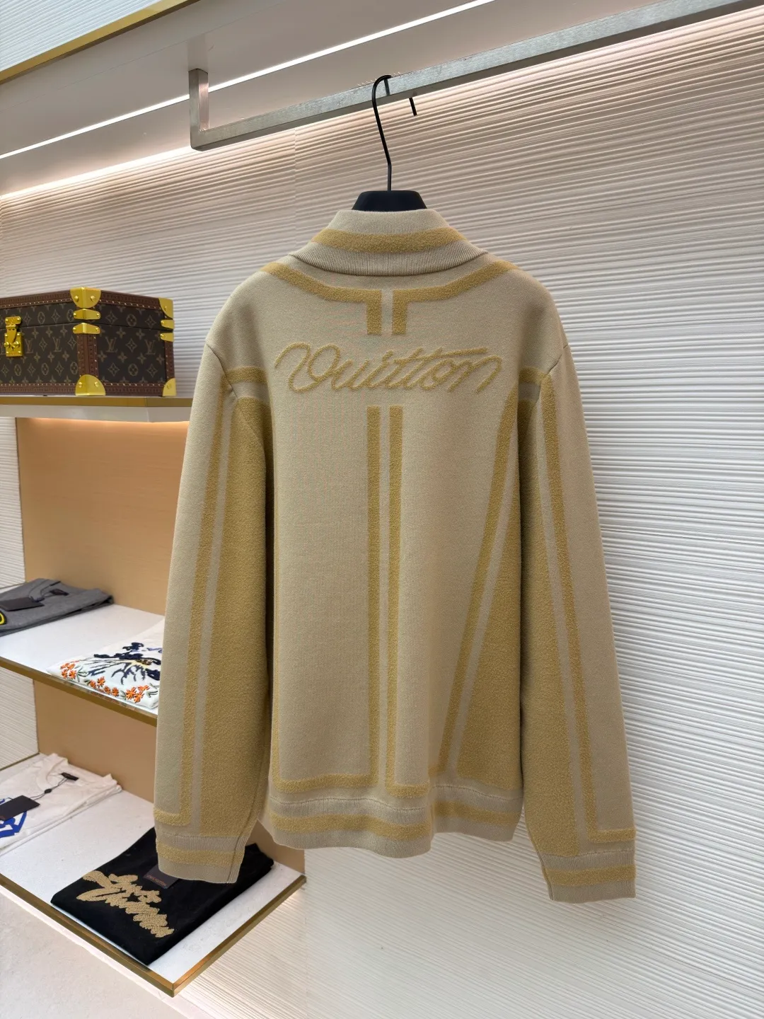 LOUIS VUITTON two-color splicing intarsia zipper jacket ●Original version: purchased and developed at 20700 ●Item number: 1681968-C15 ●Fabric: nylon fabric ●Technology: intarsia production ●Color: khaki ●Version: fitted version ●Weight: about 1020 grams ●Size: XS-S-M-L ●Description: Made of 43% nylon, 32% cotton and 25% viscose blended fabric, which has both comfort and stiffness. The designer used two-tone intarsia technology to allow contrasting color strips to run through the sleeves and body, forming a smooth visual extension. Different areas create subtle three-dimensional texture effects by changing knitting density and stitching methods. The chest is decorated with a delicate intarsia LV logo, and the Vuitton word is presented in elegant font on the back, showing brand recognition in every detail. The collar, cuffs and hem made of rib knitting technology not only enhance the stability of the silhouette, but also echo the overall design language. The front placket features a smooth zipper closure and practical slip pockets on both sides for added functionality. The entire piece perfectly interprets the exquisite aesthetics of sports and leisure style through the ingenious combination of fabric texture and craftsmanship details. The overall wiring is straight and delicate, the fabric is comfortable and soft, and the color is consistent without color difference. It can be matched with the same style to create a fashionable look and control various occasions. Customized accessories, complete with three standards, same style for men and women!